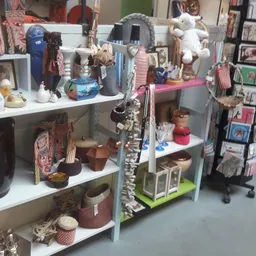 Stellingen met diverse tweedehands items zoals decoraties, servies, boeken en souvenirs