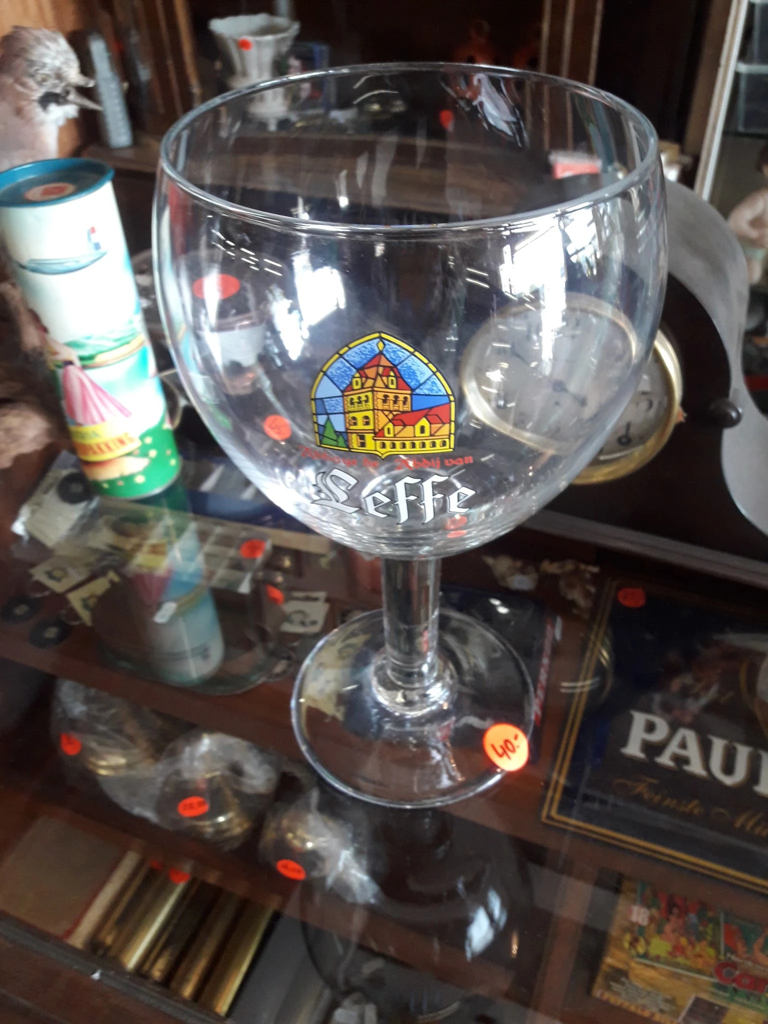 Glazen bierglas met Trappist-logo en merkopdruk op tafel