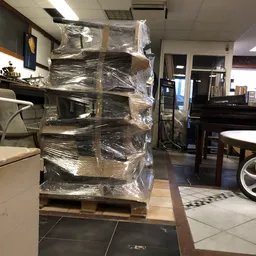 In plastic verpakte stapel meubels of huishoudartikelen op pallet in winkelruimte