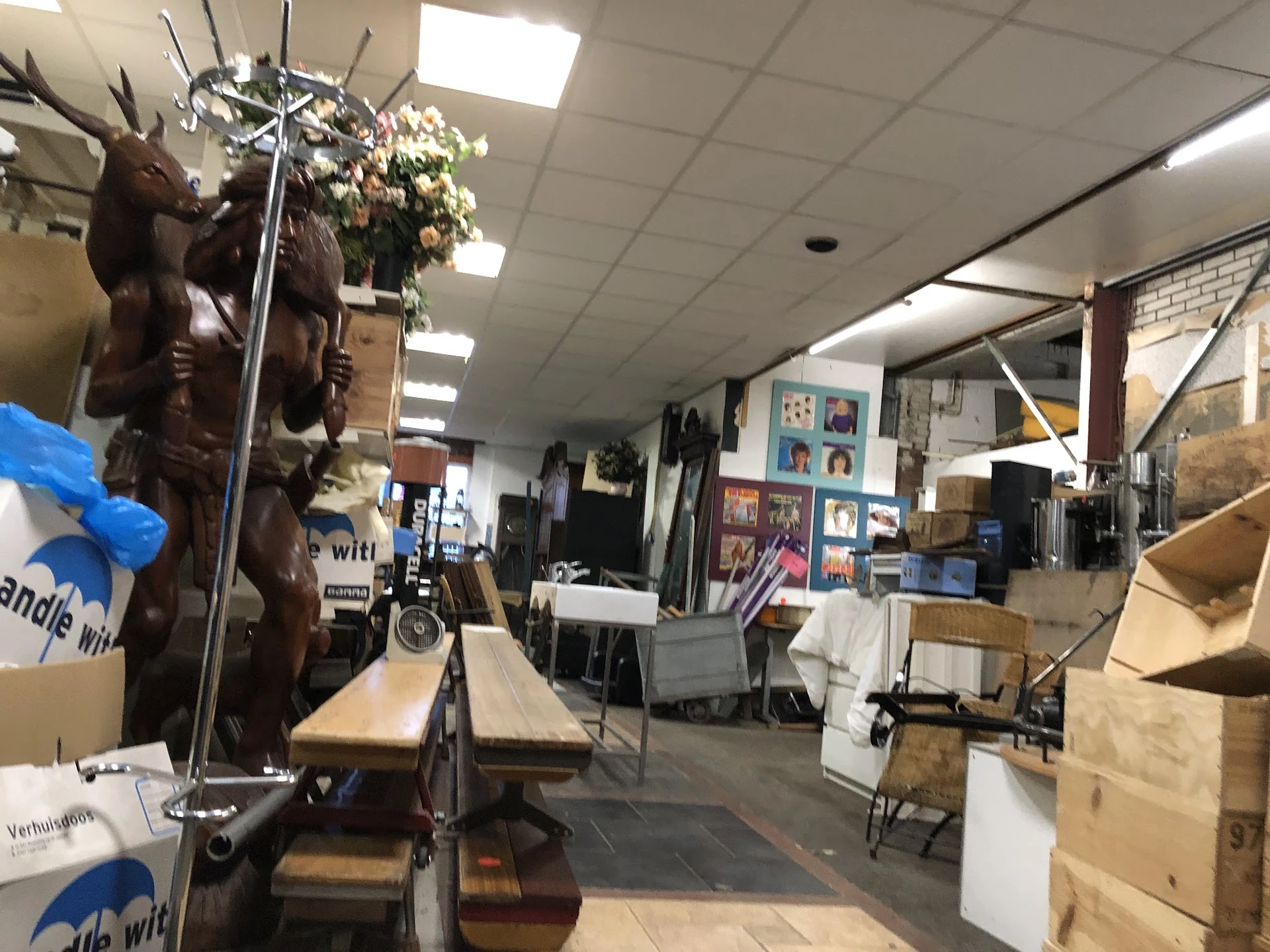 Winkelvloer met stellingen, dozen, meubels en diverse tweedehands artikelen in de kringloopwinkel