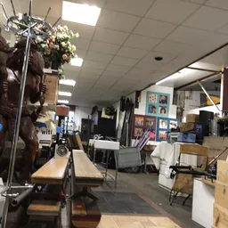 Winkelvloer met stellingen, dozen, meubels en diverse tweedehands artikelen in de kringloopwinkel
