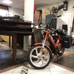 Rood-zwarte scooter of motorfiets met witte wielen in een winkelinterieur