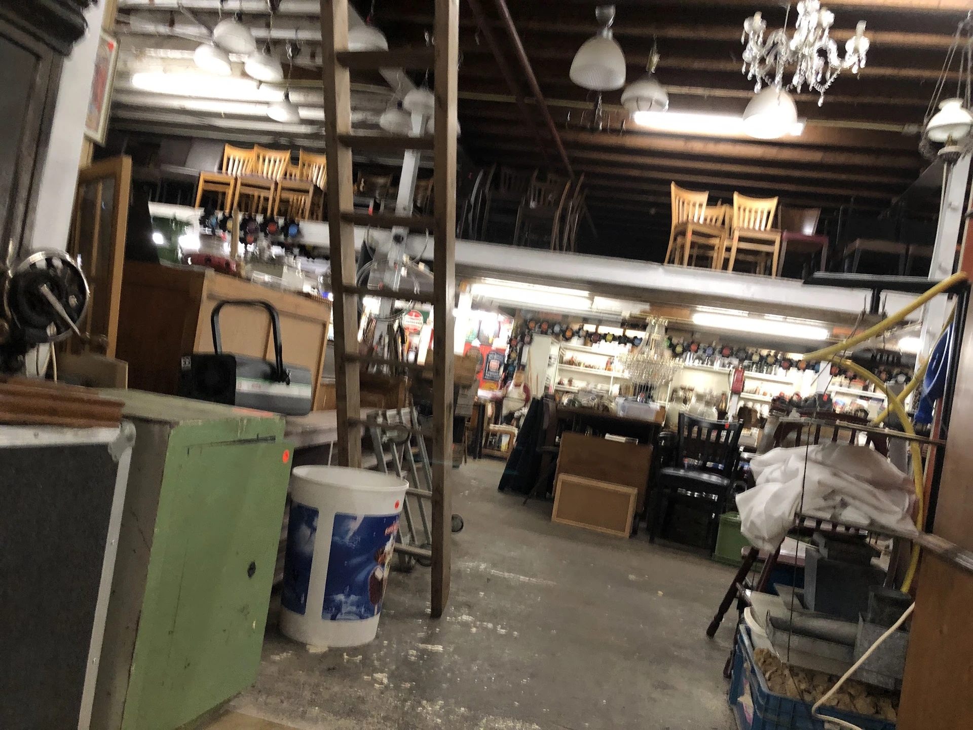 Winkelvloer met stellingen, dozen en diverse spullen in een kringloopwinkel