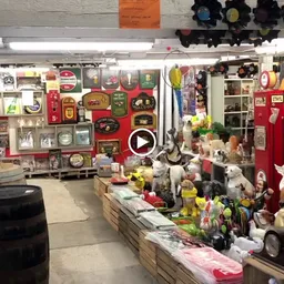 Winkelinterieur met stellingen vol decoratieartikelen, serviesgoed en huishoudelijke spullen langs de muren en op toonbanken