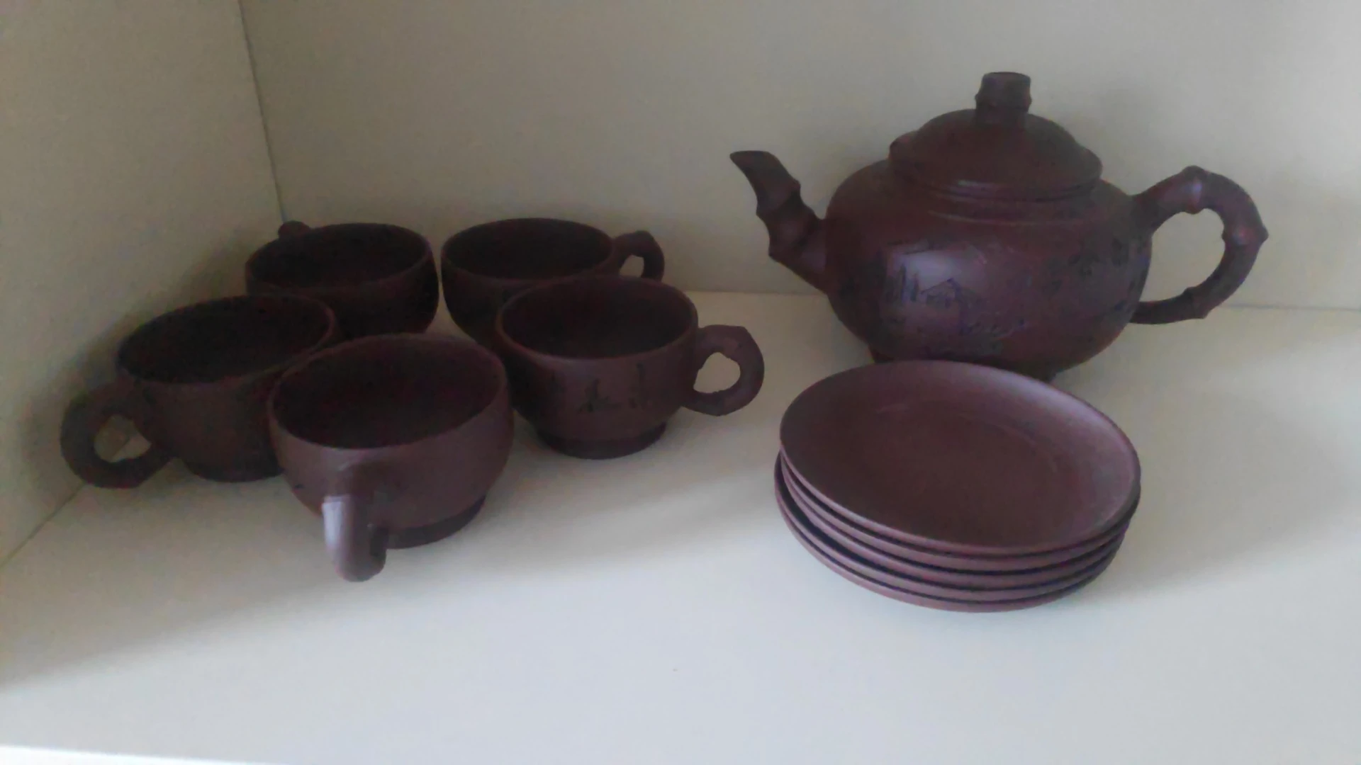 Bruin aardewerk servies: theepot, kopjes en schotels
