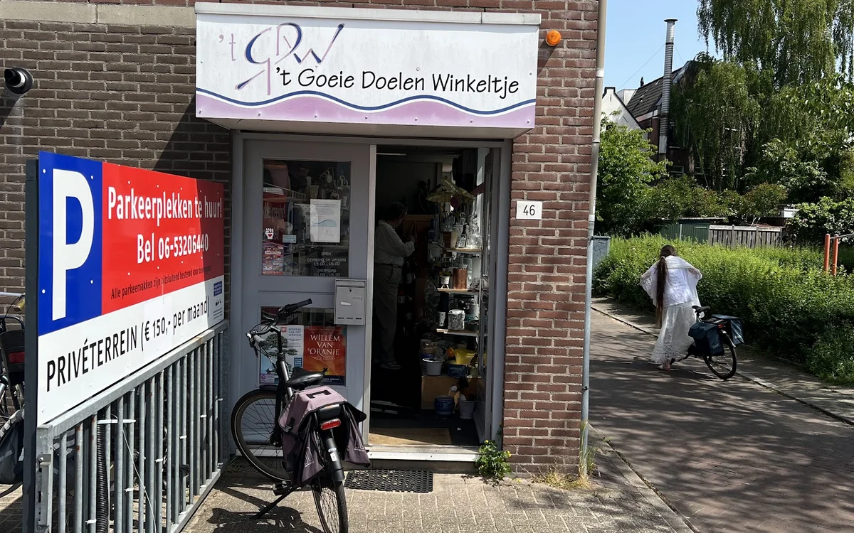 Gevel van kringloopwinkel 't Goeie Doelen Winkeltje aan Yperstraat, met winkelnaambord, deur en fietsen ervoor