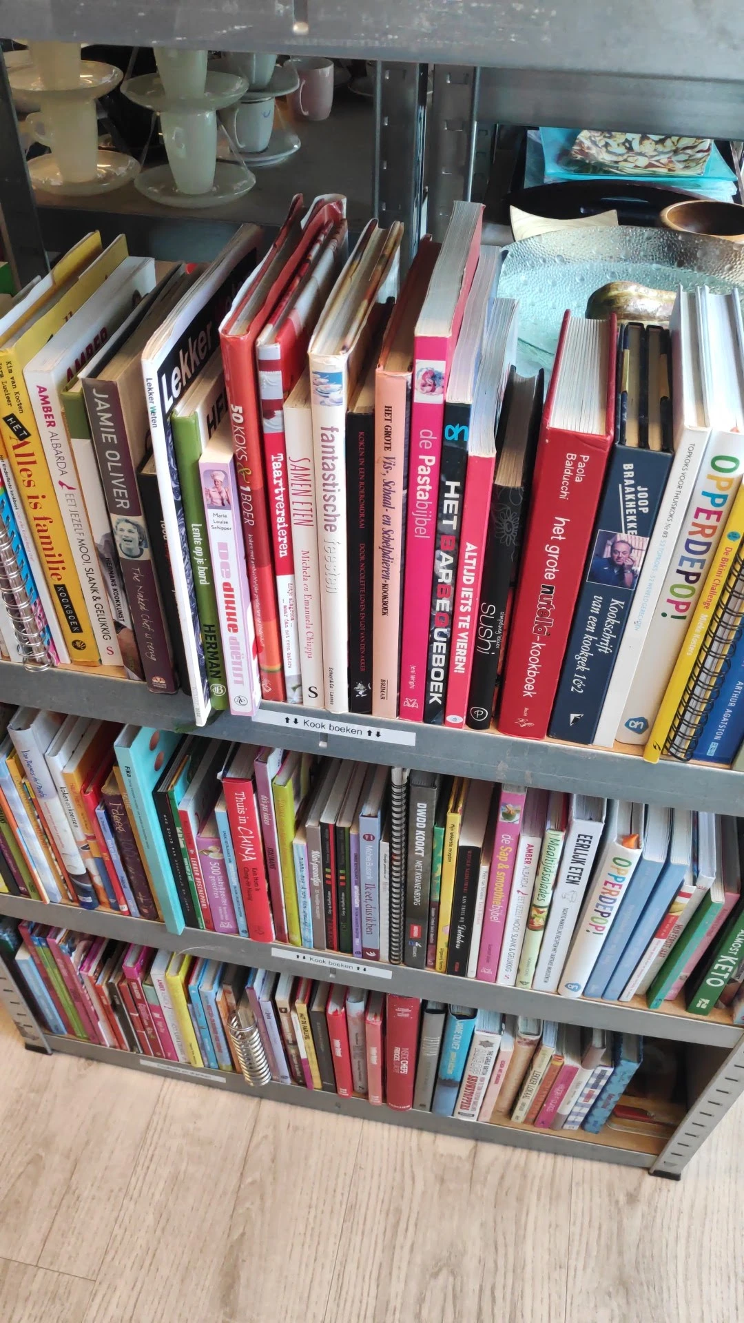 Boekenrekken met tweedehands boeken in verschillende genres en kleuren in een kringloopwinkel