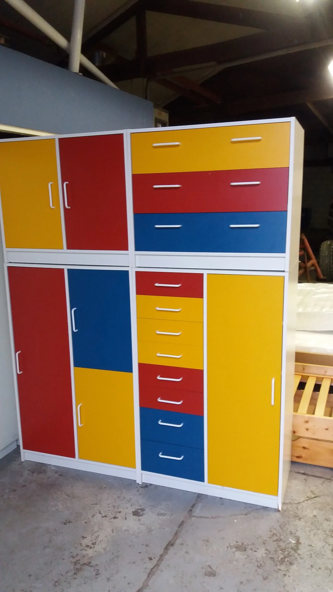 Kleurrijke modulaire kastenwand met rode, blauwe en gele vakken en laden