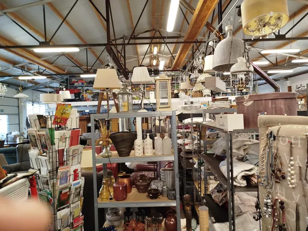 Winkelvloer met diverse stellingen vol decoraties, lampen, servies en huishoudelijke spullen