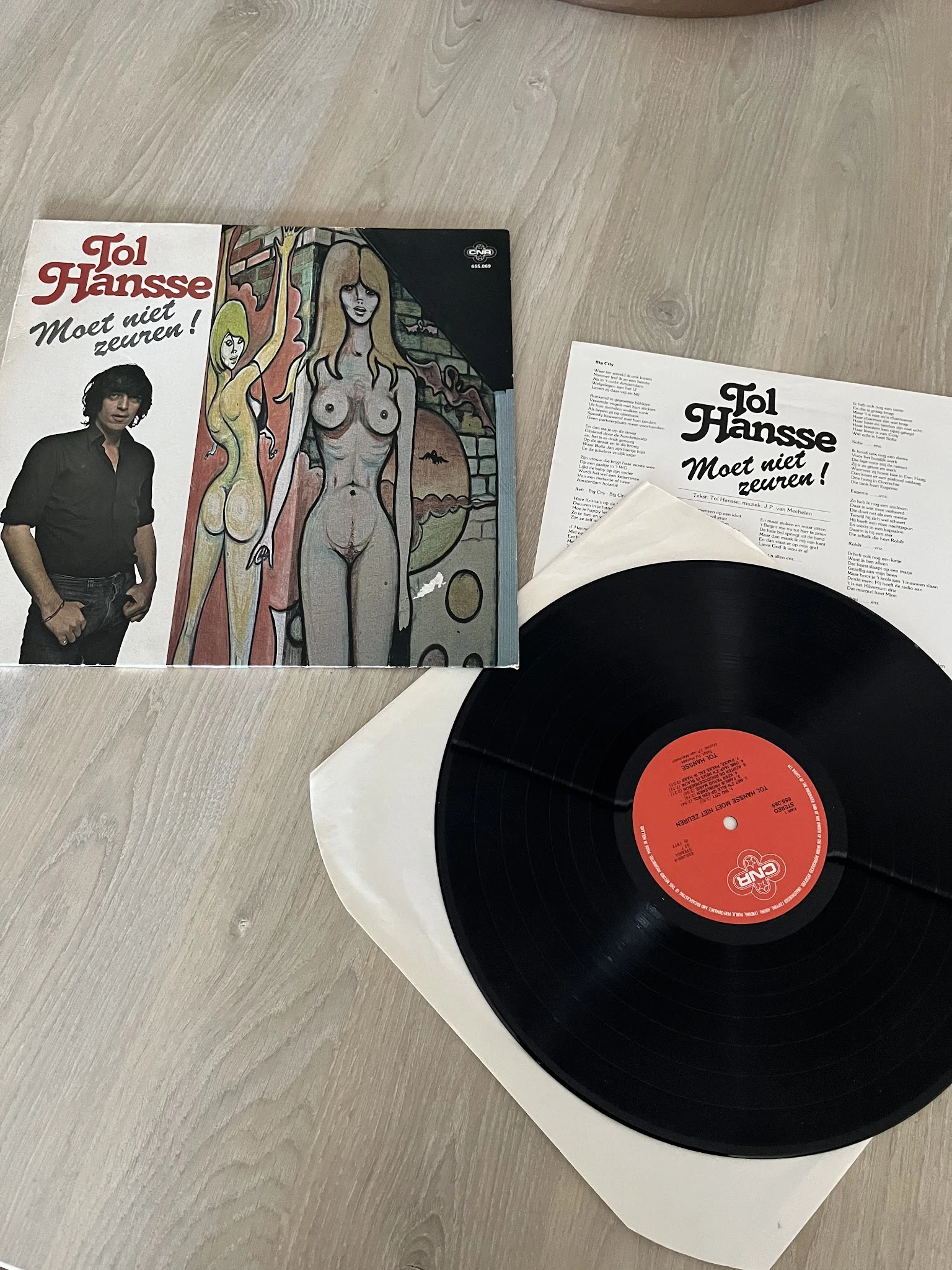 Vinyl LP 'Moot Niet Zeuren!' van Joi Jhansse met hoesje en zwarte plaat op houten ondergrond