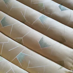 Opgerold behang of textiel met geometrisch patroon in beige, groen en wit