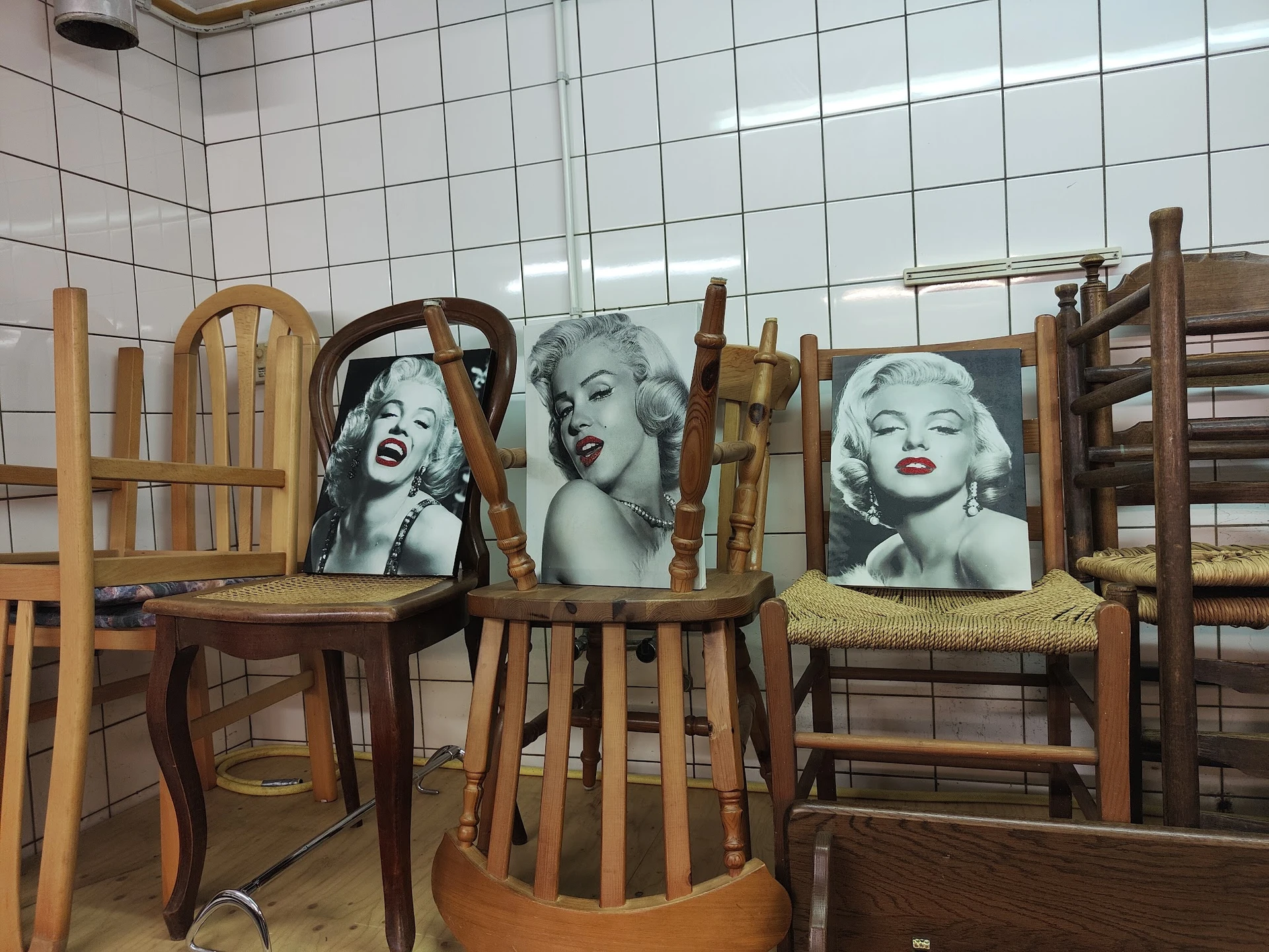 Houten stoelen met zwart-wit portretfoto's van Marilyn Monroe op de rugleuningen
