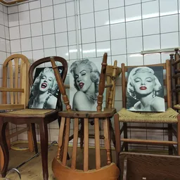 Houten stoelen met zwart-wit portretfoto's van Marilyn Monroe op de rugleuningen