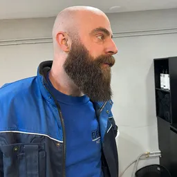 Man met baard in blauw jack in een winkelruimte