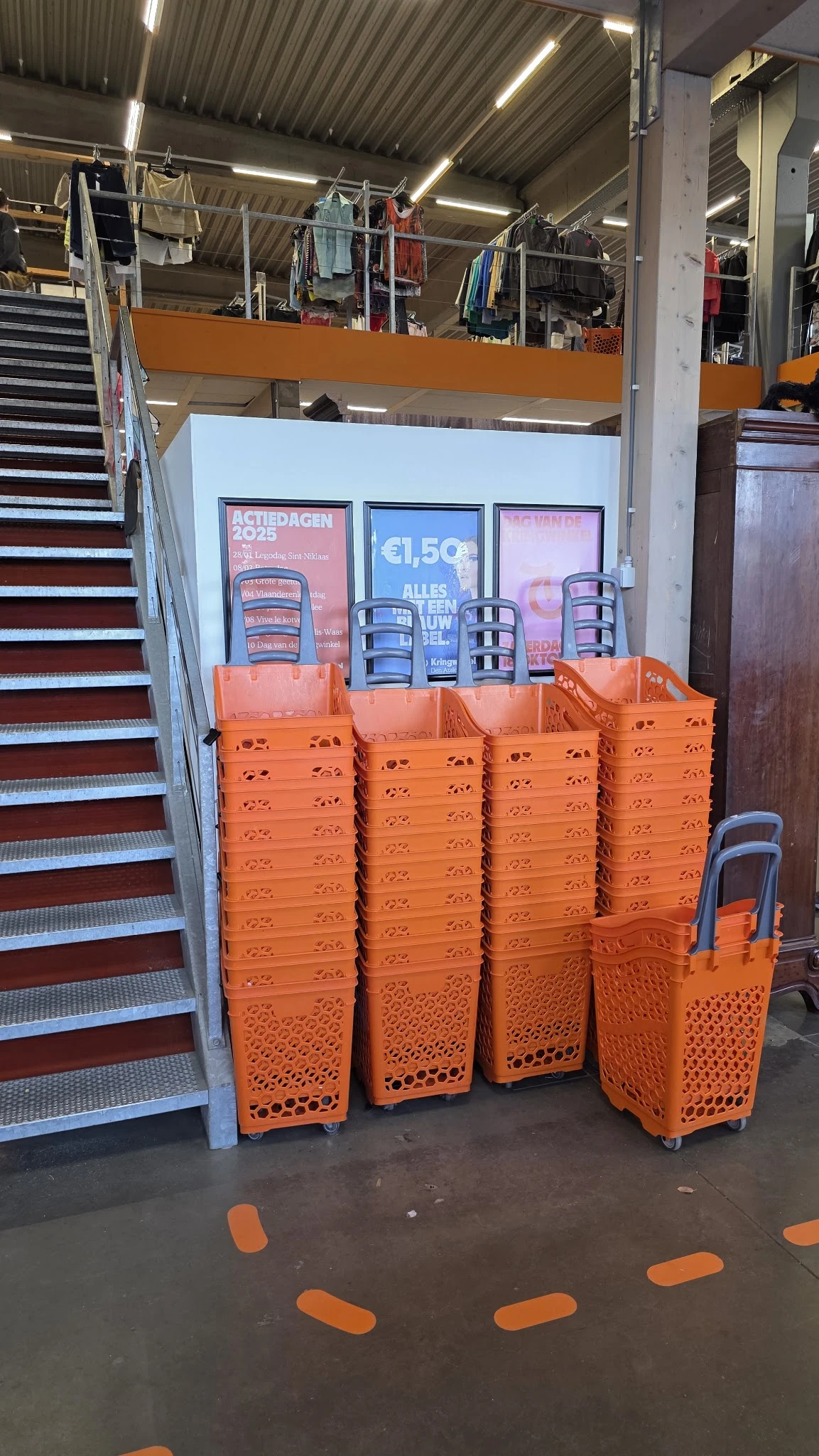 Stapels oranje kunststof kratjes met daaropDisplaykasten met merchandise in een winkel