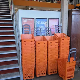 Stapels oranje kunststof kratjes met daaropDisplaykasten met merchandise in een winkel