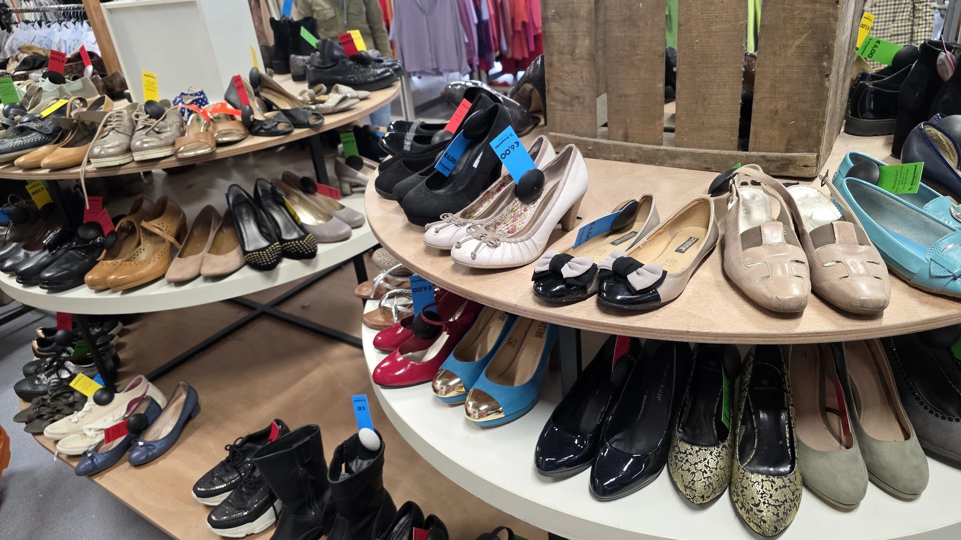 Uitgestalde tweedehands schoenen en sportschoenen op rekken in de winkel