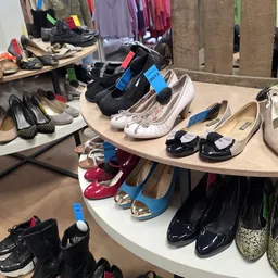 Uitgestalde tweedehands schoenen en sportschoenen op rekken in de winkel