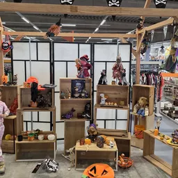 Houten stellingkasten met Halloween- en horror-thema decoraties, poppen en beelden uitgestald in de winkel