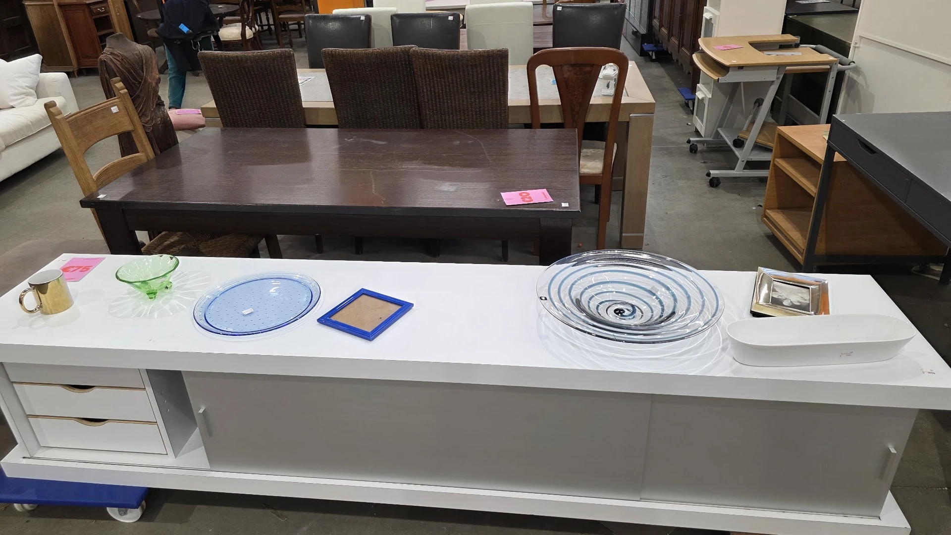 Witte toonbank met huishoudartikelen: blauwe borden, geel dienblad en spiraalvormige items