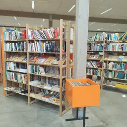 Boekenrekken met tweedehands boeken en een oranje display-element in een winkelruimte