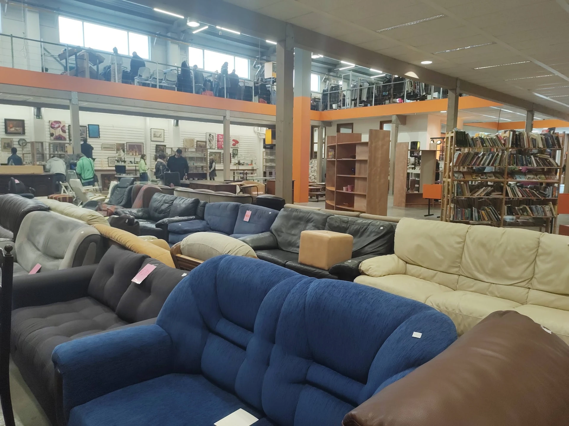 Uitgestalde fauteuils en banken in verschillende kleuren in een kringloopwinkel