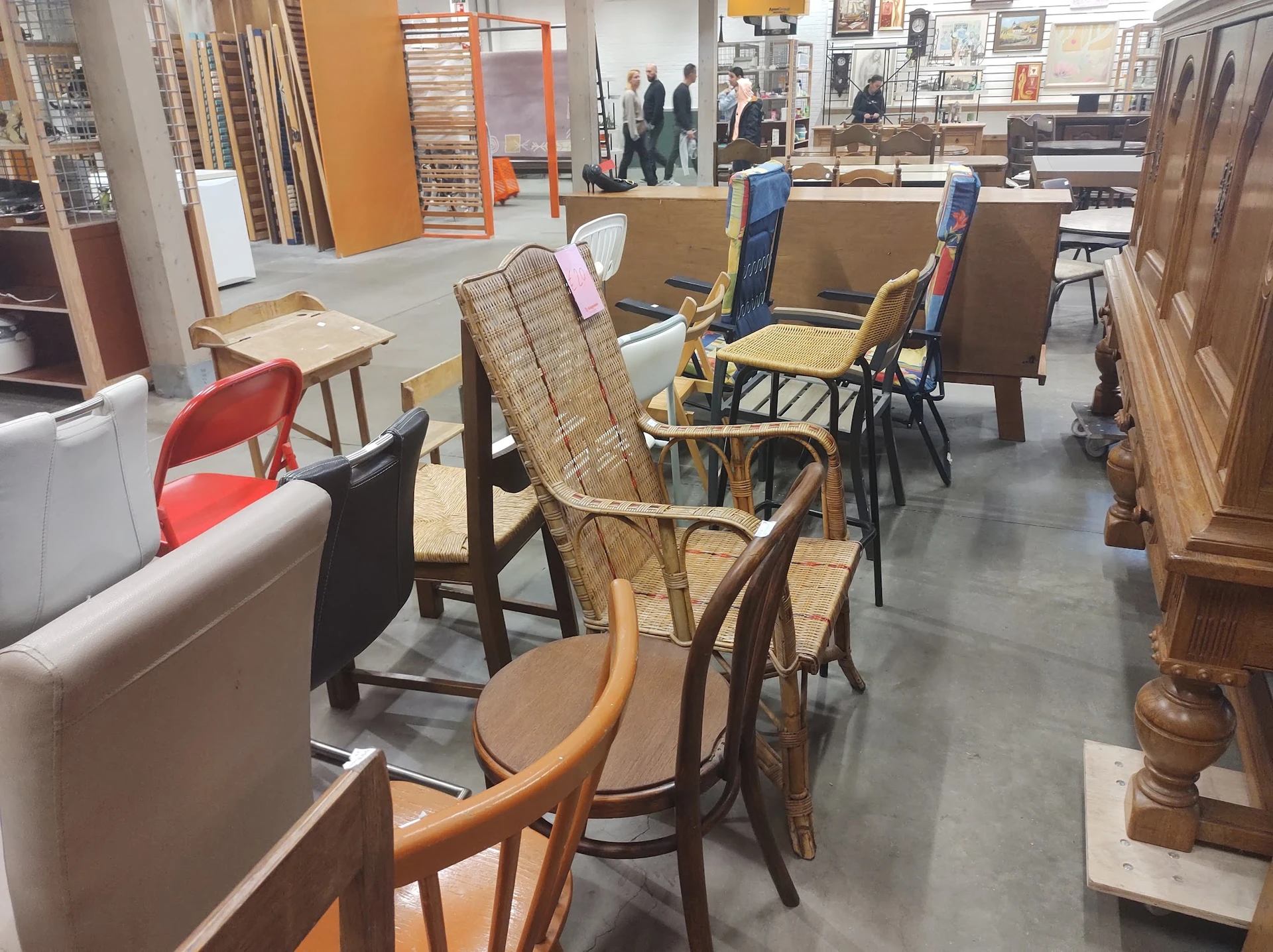 Winkelinterieur met diverse meubels: stoelen, fauteuils en kasten tegen wanden en in het gangpad.