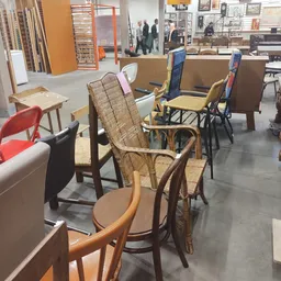 Winkelinterieur met diverse meubels: stoelen, fauteuils en kasten tegen wanden en in het gangpad.