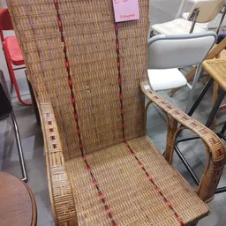 Rotan stoel met rood en crème gestreepte bekleding, gezien van voren in de winkel