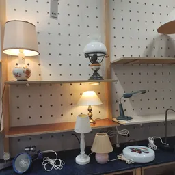 Uitgestalde lampen en verlichting op pegboard en toonbank in kringloopwinkel