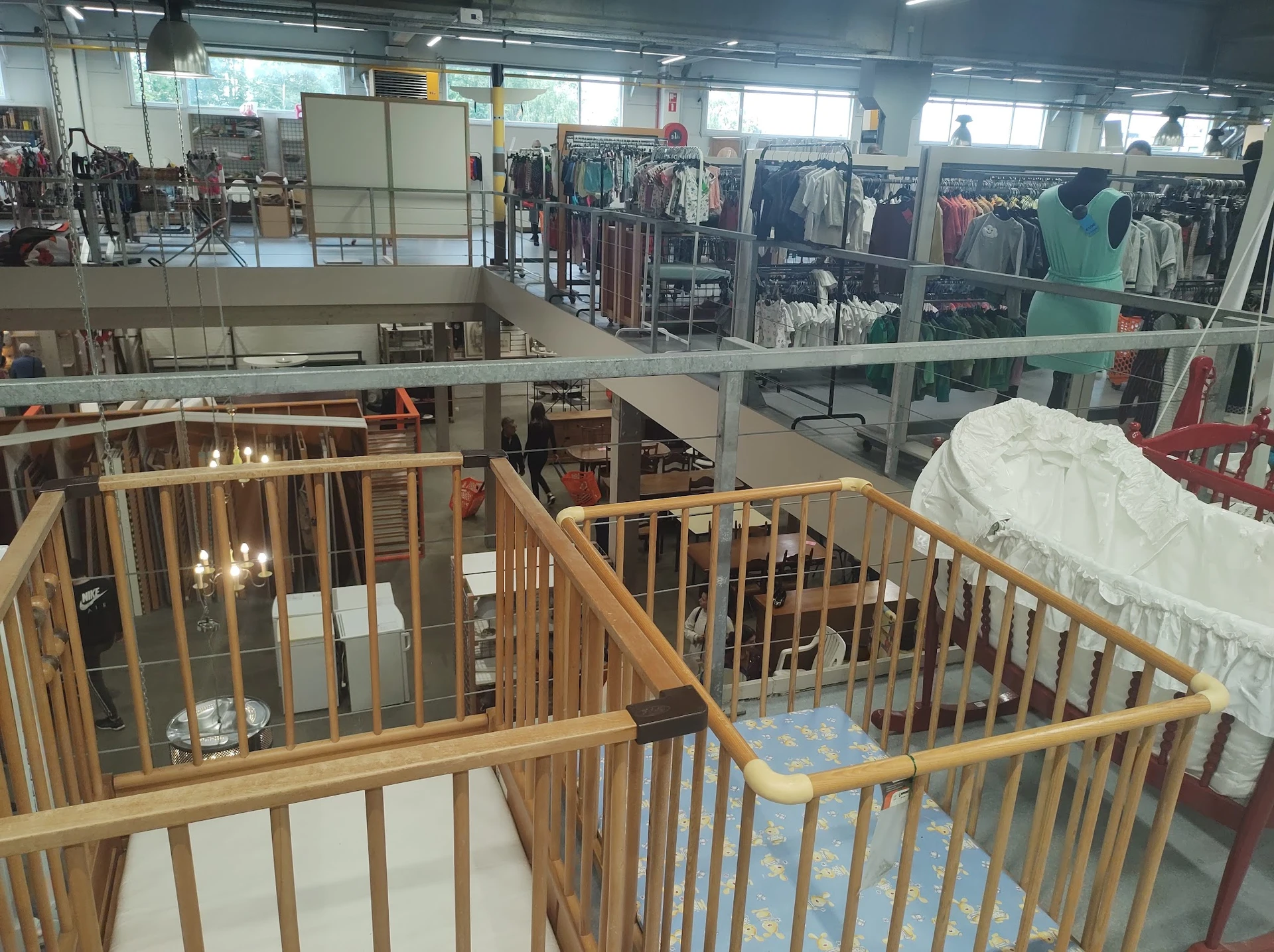 Houten babywiegjes en kindermeubels uitgestald op de tweede verdieping van de winkel