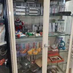 Glazen vitrinekasten met tweedehands verzamelaars items, speelgoed, dvd's en boeken
