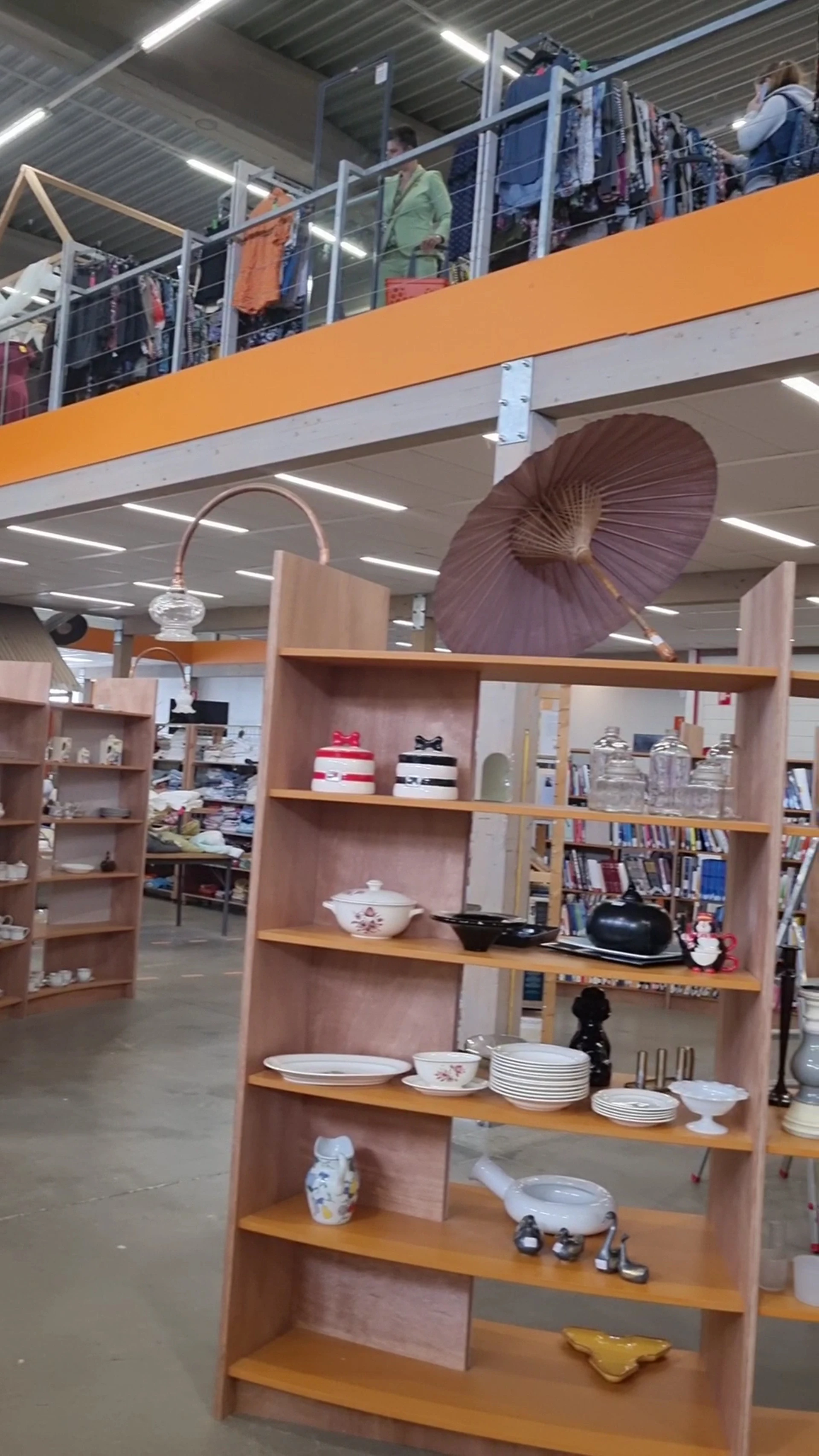 Winkelinterieur met houten stellingen vol huishoudartikelen, decoratie en boeken