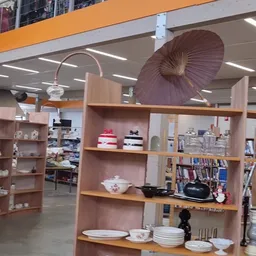 Winkelinterieur met houten stellingen vol huishoudartikelen, decoratie en boeken
