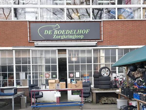 Voorgevel van kringloopwinkel De Boedelhof Zorgkringloop met winkelnaam op signage, uitstallingen en ingang zichtbaar