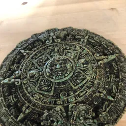 Groene stenen Azteekse kalender met gedetailleerde reliëfwerk en symbolen