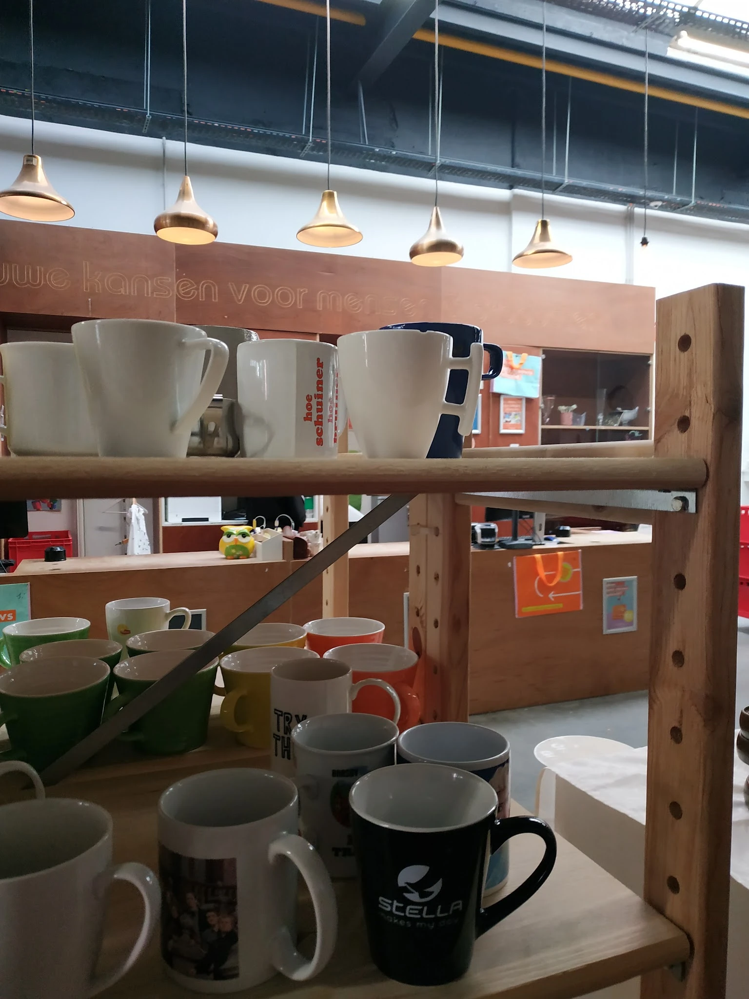 Houten stellingkast met diverse servies, kopjes en huishoudartikelen op meerdere niveaus