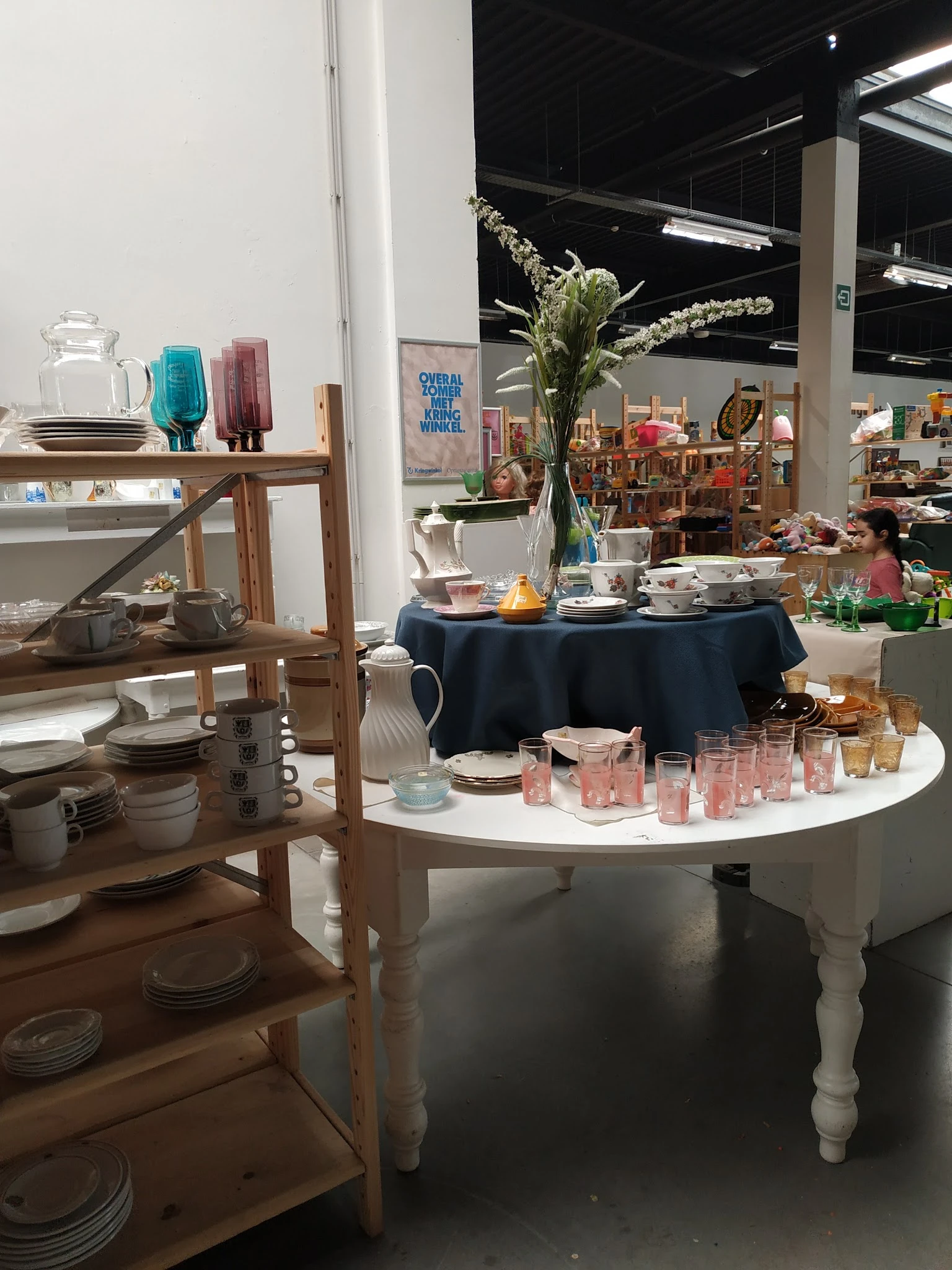 Uitgestalde tafelwaar, kandelaren en decoratieve items op ronde tafels in de winkel