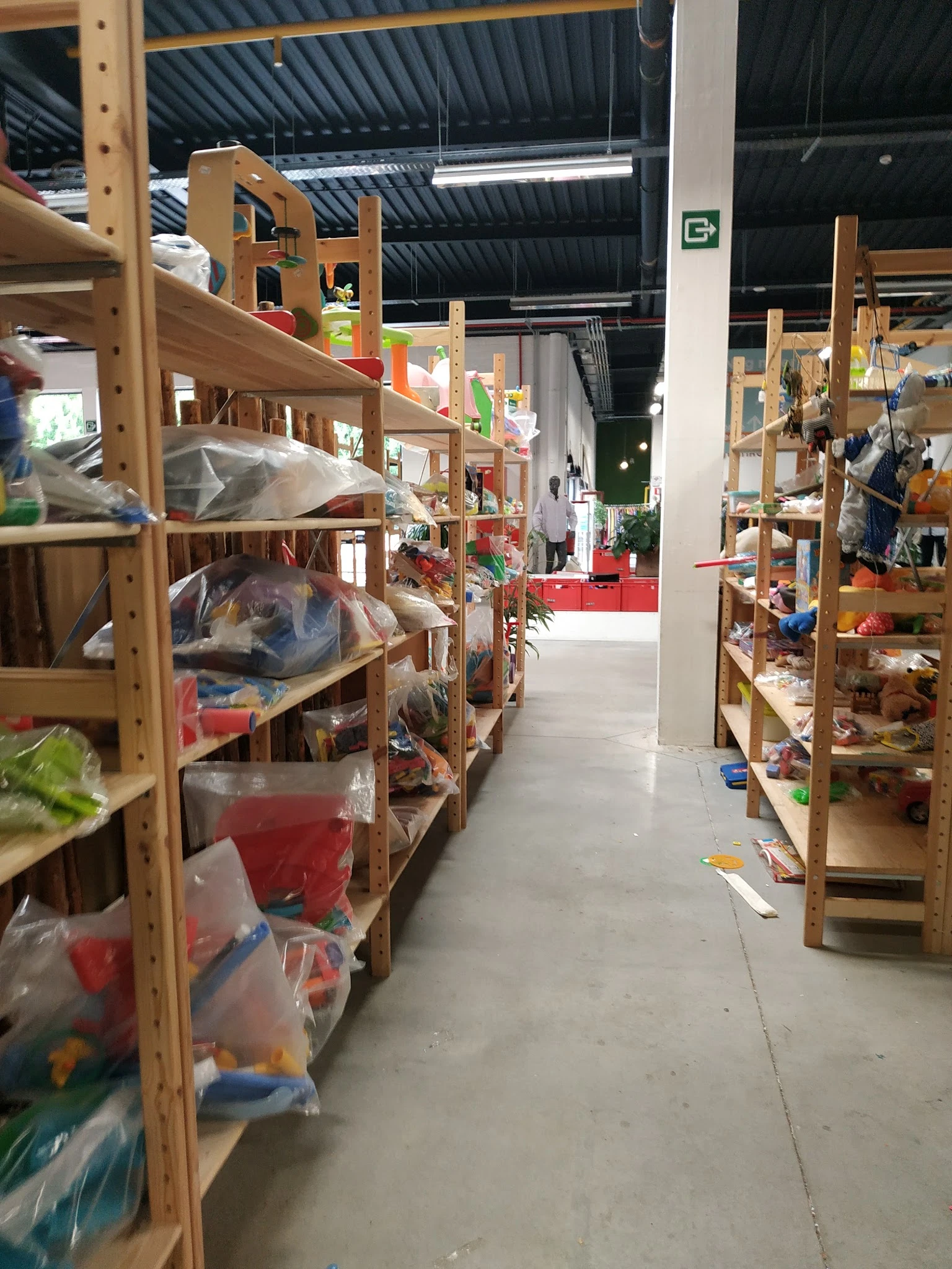 Winkelinterieur met houten stellingen vol opgeslagen goederen in plastic bakken en dozen