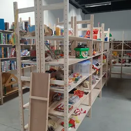 Houten stellingen met boeken, speelgoed en diverse tweedehandsartikelen in kringloopwinkel