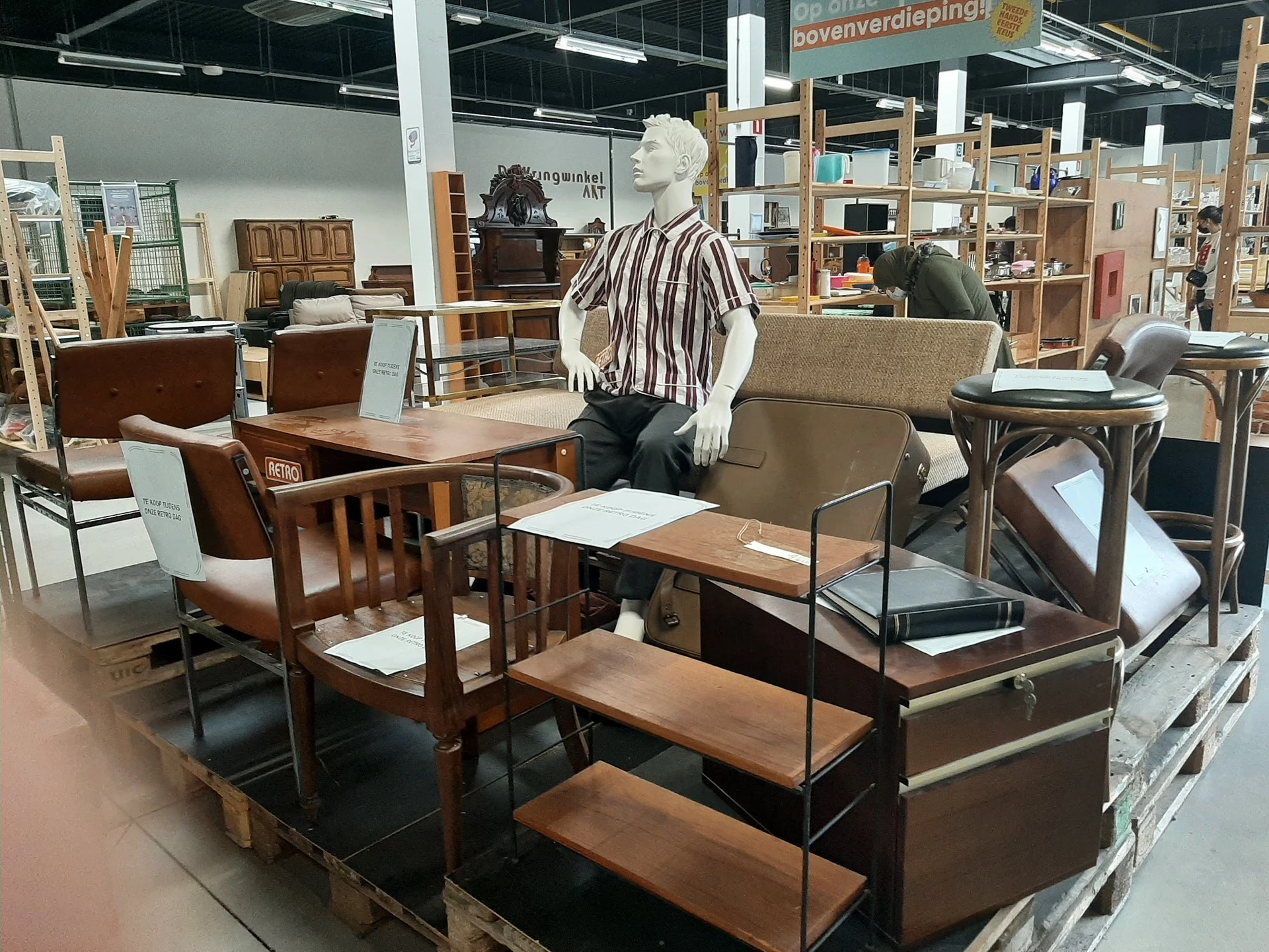 Uitgestalde meubels in de winkel: houten stoelen, tafels, fauteuils en kasten