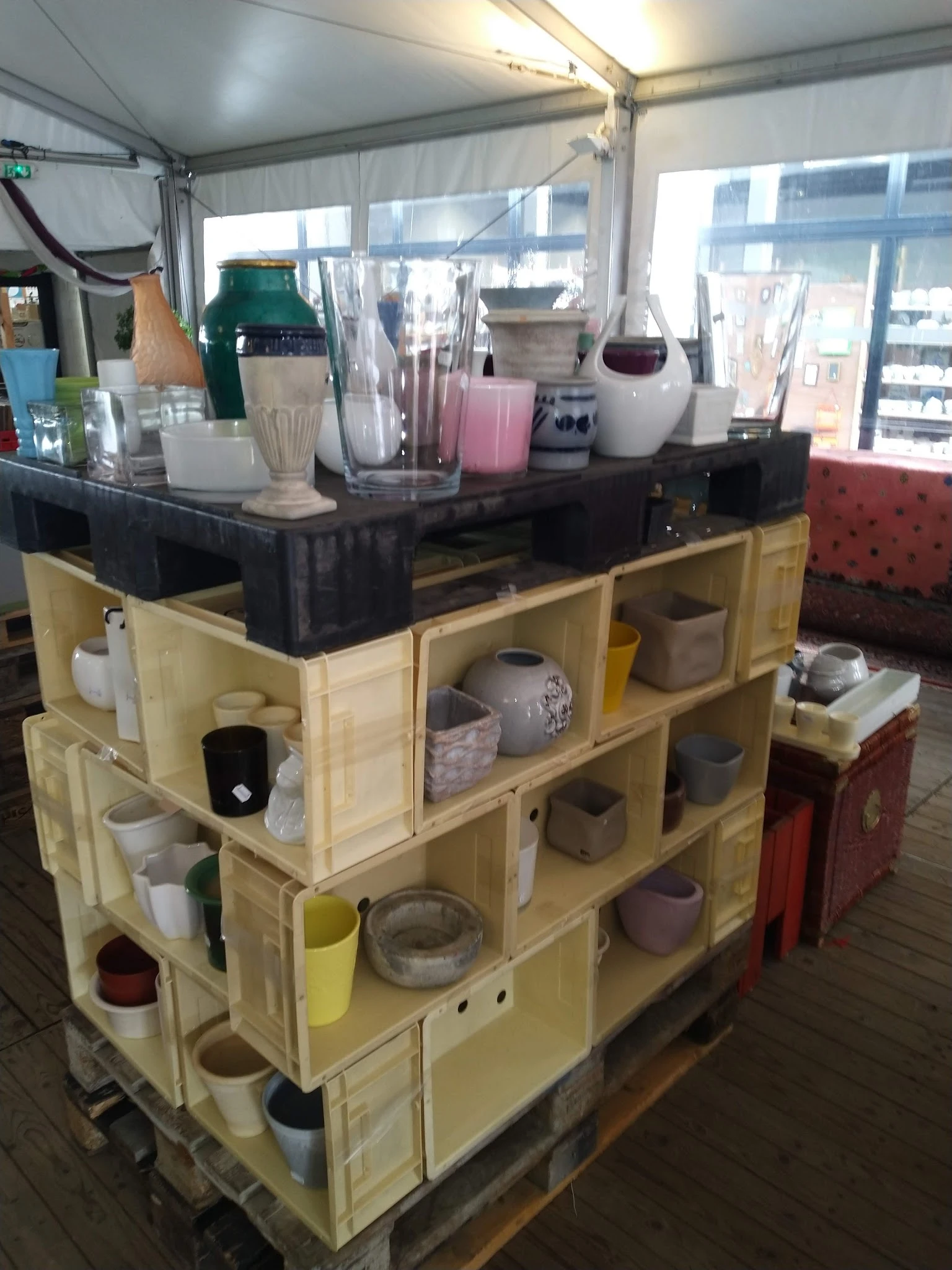 Houten stellingkast met verschillende huishoudartikelen, vazen, bekers en decoratieve voorwerpen uitgestald