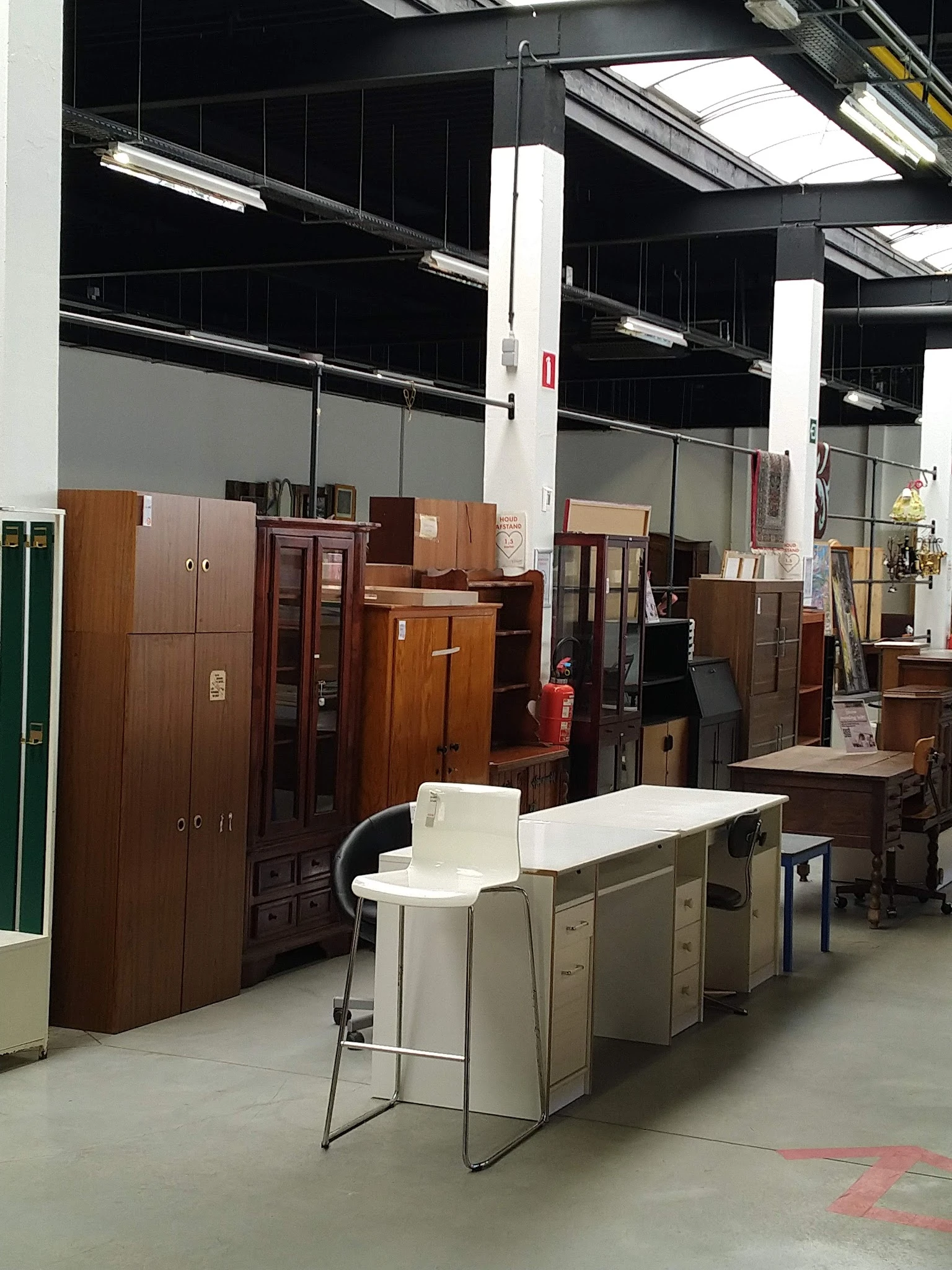 Diverse houten kasten, dressoirs en meubels uitgestald in de kringloopwinkel