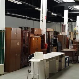 Diverse houten kasten, dressoirs en meubels uitgestald in de kringloopwinkel