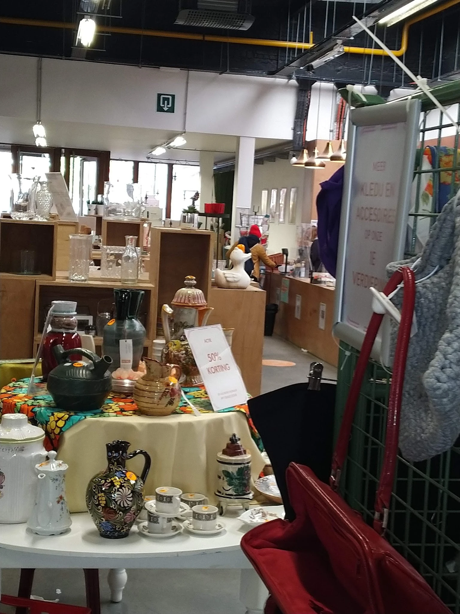 Uitgestalde huishoudelijke artikelen en decoratie op tafel in tweedehands winkel