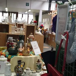 Uitgestalde huishoudelijke artikelen en decoratie op tafel in tweedehands winkel