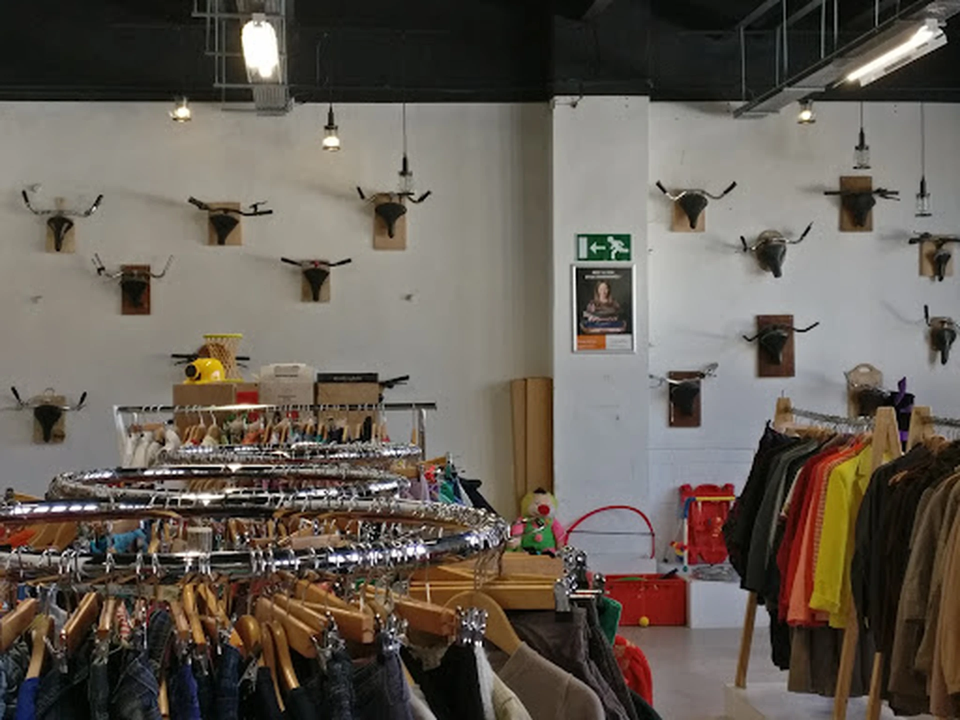 Winkelvloer met kledingrekken en decoratieve dierenkoppen aan de muur