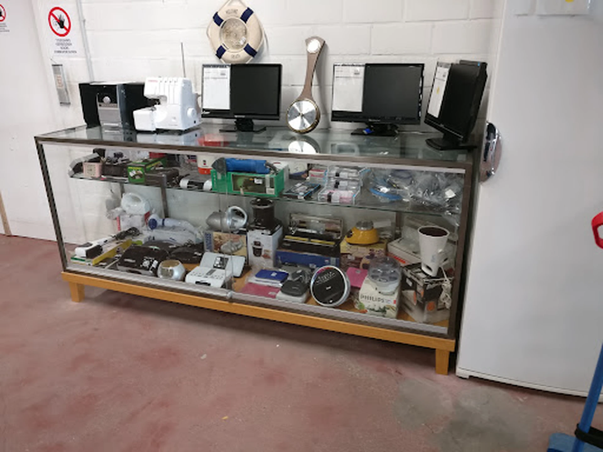 Glazen vitrinekast vol met elektronische onderdelen, gereedschap en diverse spullen op de winkelvloer