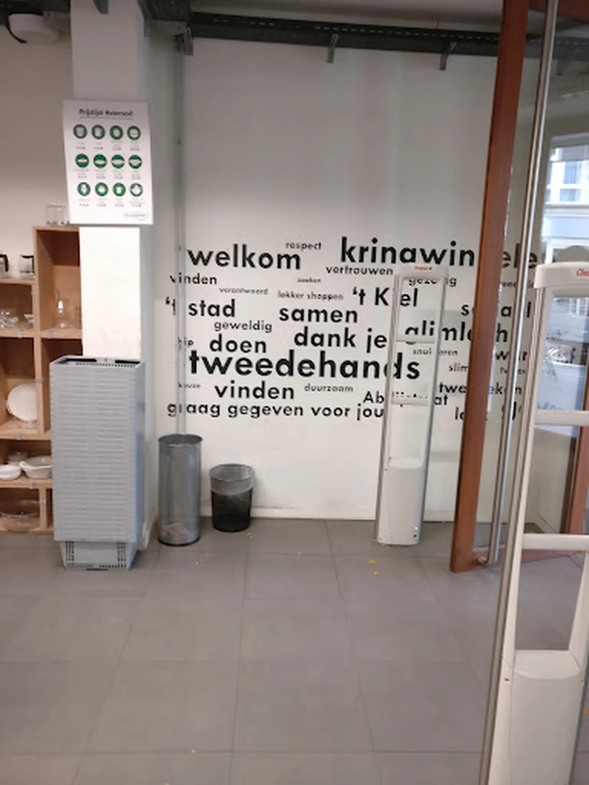 Winkelinterieur met wanddecoratie met Nederlandse woorden, afvalbakken en rekken