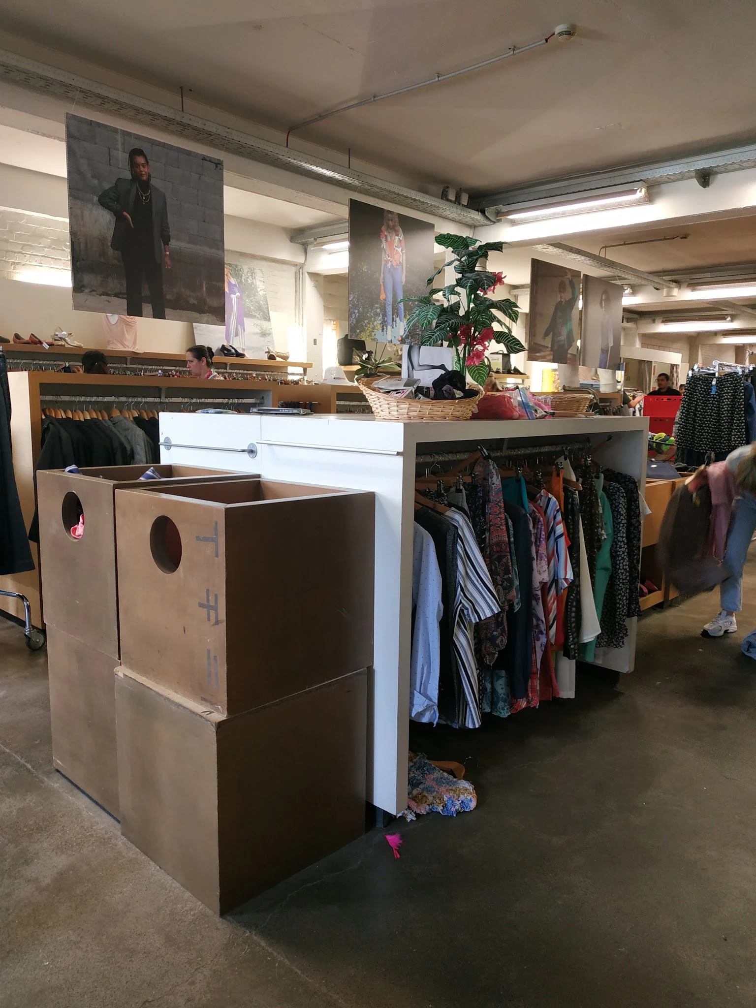 Winkelinterieur met kledingrekken, verrijdbare stellingen en uitgestalde tweedehands kleding